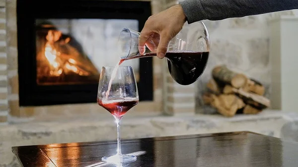Мужская рука наливает красное вино в бокал на фоне — стоковое фото