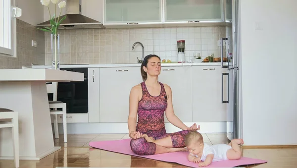 Ung Mamma Gör Yoga Eller Mediterar Med Barnet Köket Hom — Stockfoto