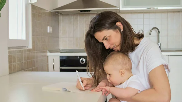 Young Mother Writes Notebook Plans Baby Kitchen Hom — Stock Photo, Image