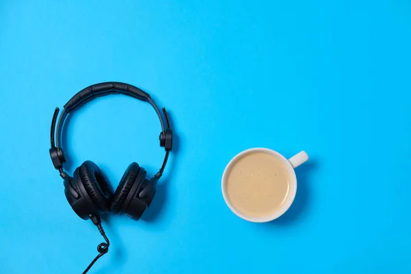 Música ou podcast fundo com fones de ouvido e xícara de café em — Fotografia de Stock