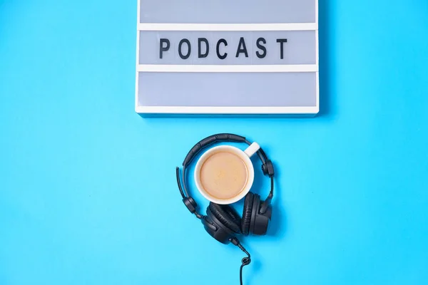 Musik bakgrund med Podcast word på ljusbord, hörlurar och — Stockfoto