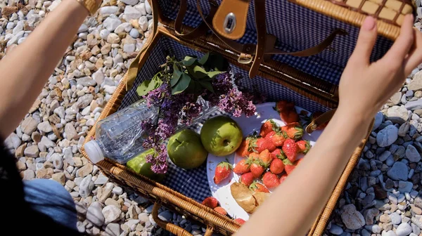 Nahaufnahme eines sommerlichen Picknickkorbs mit Wasser, Obst und Croissant — Stockfoto