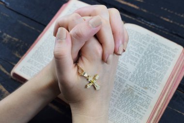 Kız onun elinde tutan çapraz İncil dua