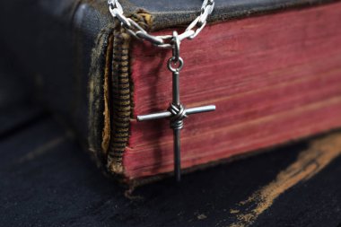 Gümüş haç eski kutsal İncil'in üzerine yatıyor