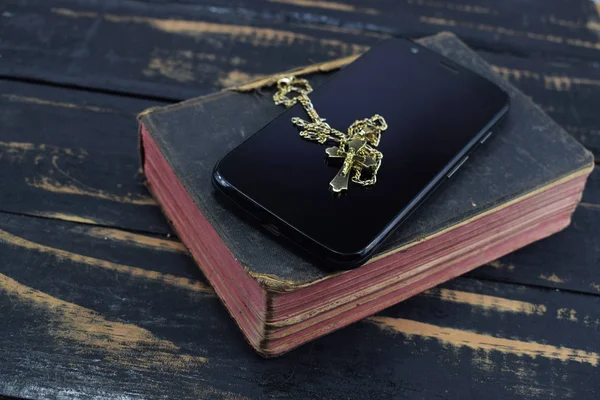 金色十字 手机和古老的圣经在桌上 — 图库照片