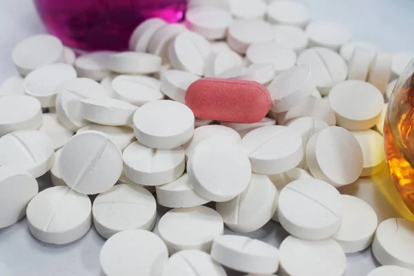 bir sürü ortasında pembe bir beyaz yuvarlak tablet ve kimyasallar, toptan ile farklı pamuk şişeler