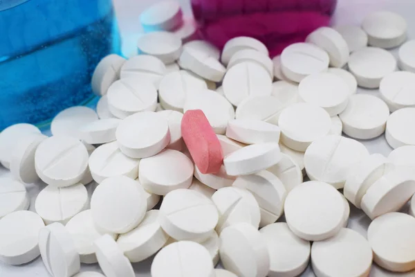 bir sürü ortasında pembe bir beyaz yuvarlak tablet ve kimyasallar, toptan ile farklı pamuk şişeler