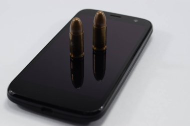 mermi bir tabanca, farklı kartuşları ve beyaz bir arka plan üzerinde bir cep telefonu için mücadele