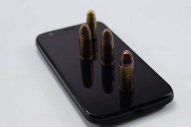 mermi bir tabanca, farklı kartuşları ve beyaz bir arka plan üzerinde bir cep telefonu için mücadele