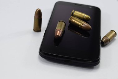 mermi bir tabanca, farklı kartuşları ve beyaz bir arka plan üzerinde bir cep telefonu için mücadele