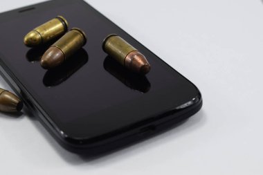 mermi bir tabanca, farklı kartuşları ve beyaz bir arka plan üzerinde bir cep telefonu için mücadele