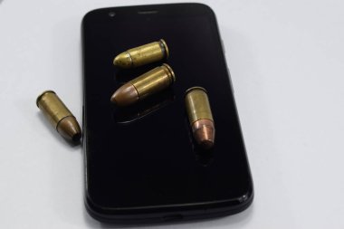 mermi bir tabanca, farklı kartuşları ve beyaz bir arka plan üzerinde bir cep telefonu için mücadele