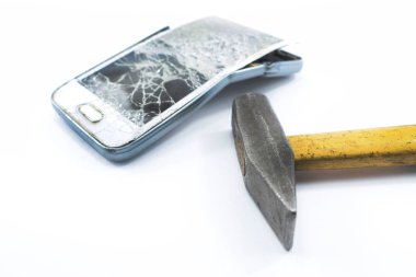 beyaz zemin üzerinde bir çekiç ile kırık cep telefonu