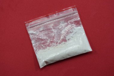 bir paket uyuşturucu (eroin) kırmızı bir arka plan üzerinde