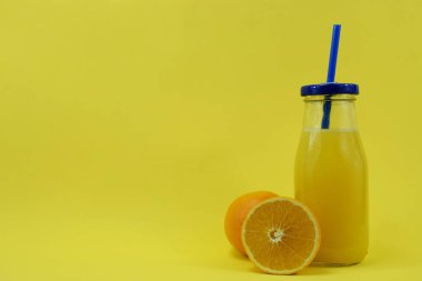 Bir bardak taze aleklin suyu ile ve bir portakal yanında yatıyor.