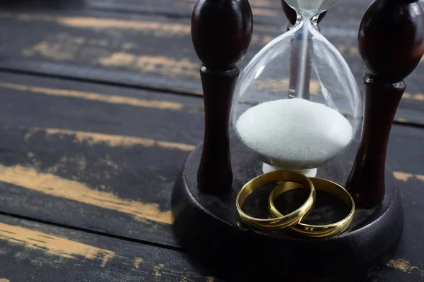 wedding rings and hourglass. together forever while death does not divide us