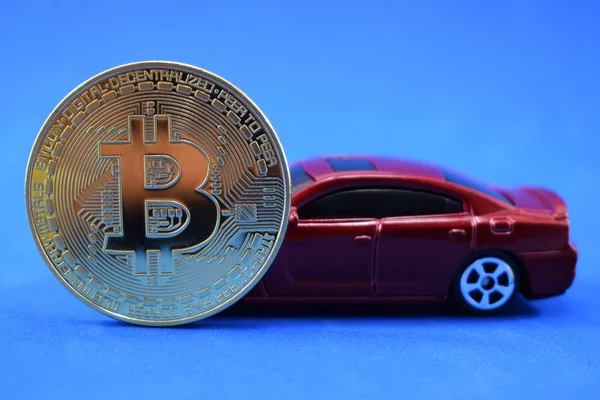 jeton bitcoin ve kırmızı araba mavi bir arka plan, zenginlik ve başarı sembolü