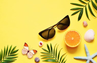 Tropikal arka plan. Palmiye ağaçların dalları ile deniz yıldızı ve Sarı zemin üzerine deniz kabuğu. Seyahat. Kopya alanı