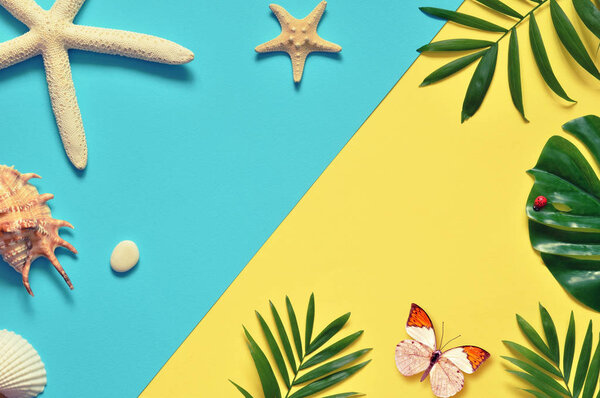 Tropical Background. Palm Trees Branches with starfish and seashell on yellow and blue background. Travel. Copy space