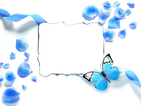 Spring top view composition: modelo estacionário em branco pétalas espalhadas ao redor, borboleta voadora azul. Copiar espaço para texto. Depósito plano . — Fotografia de Stock