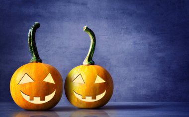 Korkunç Halloween pumpkins mavi bir arka plan üzerinde izole. Korkunç gülümseyen oyun ya da şeker yüzler.