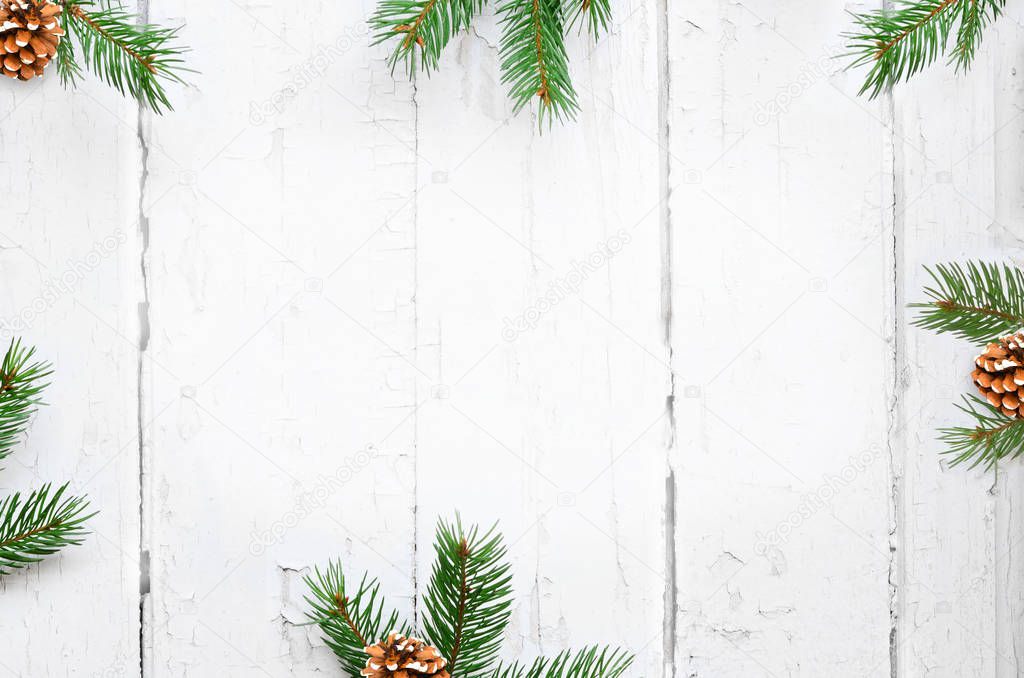Christmas background with fir branches, pinecones on the old wooden board in vintage style.