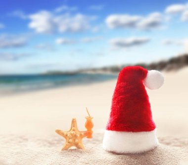 Tropikal plaj beyaz kum üzerinde Santa Claus şapka. Noel ve Yılbaşı tatil kavramı