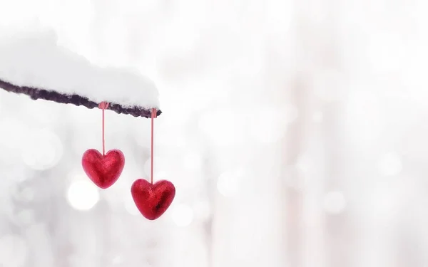 Красные сердца на ветке снежного дерева зимой. Праздники с праздником — стоковое фото