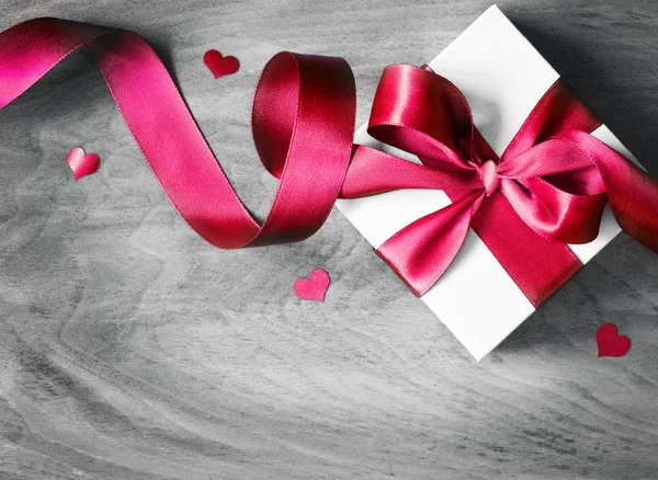 Caja de regalo blanca y cinta roja con etiqueta sobre fondo de madera. Caja de regalo vintage en tablero de madera con espacio para texto . — Foto de Stock