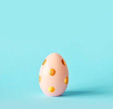 Paskalya yumurtası pastel mavi zemin üzerine. Mutlu Paskalya kavramı. En az kavramı