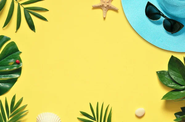 Tropiska bakgrunden. Palm träd grenar med sjöstjärnor och seashell på gul bakgrund. Resor. Kopiera utrymme. — Stockfoto