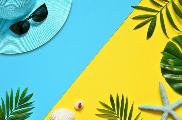 Tropikal arka plan. Palmiye ağaçların dalları ile deniz yıldızı ve deniz kabuğu sarı ve mavi arka plan üzerinde. Seyahat. Kopya alanı.