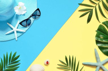 Tropikal arka plan. Palmiye ağaçların dalları ile deniz yıldızı ve deniz kabuğu sarı ve mavi arka plan üzerinde. Seyahat. Kopya alanı.