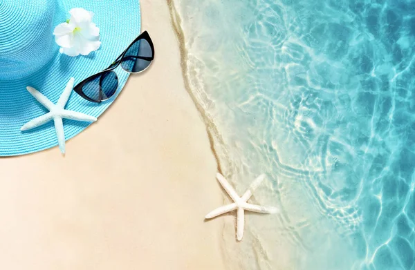Sombrero y gafas de sol en la playa de arena. Fondo de verano —  Fotos de Stock