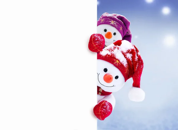 冬の雪の上に帽子とスカーフを持つ女の子と少年の2人の小さな雪だるま。面白い雪だるまとの背景。クリスマスカード. — ストック写真