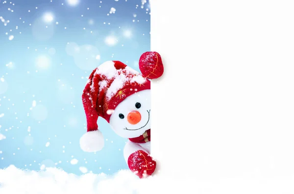 冬の雪の上に帽子とスカーフの小さな雪だるま。面白い雪だるまとの背景。クリスマスカード. — ストック写真