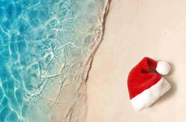 Concetto vacanze di Natale. Vista dall'alto del cappello di Babbo Natale sulla spiaggia di sabbia estiva . — Foto Stock
