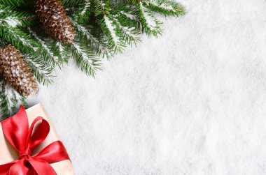 Noel arka plan, yeşilçam dalları, koniler ve kar arka plan üzerinde hediye kutusu. Kenarlık ve kopyalama alanı ile yaratıcı kompozisyon, üst görünüm. Yılbaşı, tatil, noel, dekorasyon.