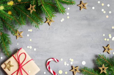 Noel hediye kutusu, şeker kamışı ve gri arka plan üzerinde köknar ağacı dalı. Kopyalama alanı ile üst görünüm. Noel dekorasyonu.