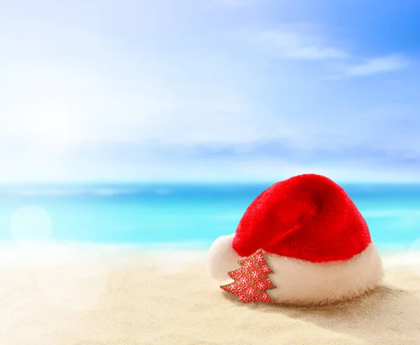 크리스마스 휴일 개념입니다. 여름 모래 해변에서 산타 클로스 모자 — 스톡 사진