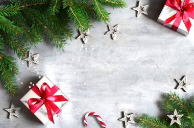Noel hediye kutusu, şeker kamışı ve gri arka plan üzerinde köknar ağacı dalı. Kopyalama alanı ile üst görünüm. Noel dekorasyonu.