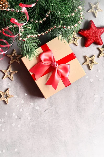 Karácsonyi háttér, zöld fenyő ágak, kúp és ajándék doboz szürke alapon. Kreatív kompozíció másolási hellyel, felülnézetben. Újévi ünnep, karácsony. — Stock Fotó