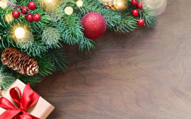 Noel tebrik kartı geçmişi ve hediyeli köknar dalları. Ahşap arkaplan.