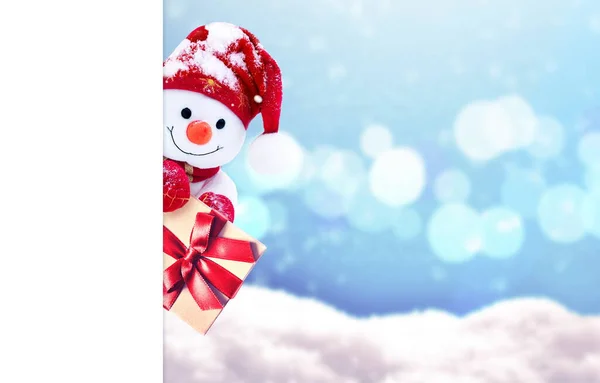 冬に雪の上の贈り物やスカーフでキャップに小さな雪だるま 面白い雪だるまとお祭りの背景 クリスマスカードコピースペース — ストック写真