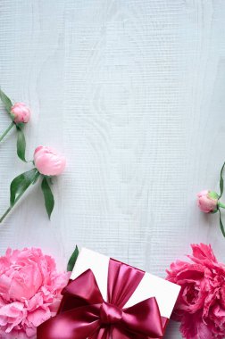 Gri arka planda şakayık ve hediye kutusu olan güzel bir kompozisyon. Tatil kavramı.