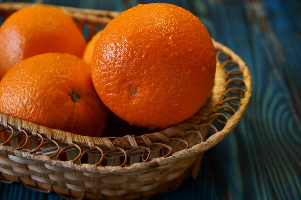 バスケットに新鮮なオレンジ 木製のテーブルのバスケットに新鮮なジューシーなオレンジ — ストック写真