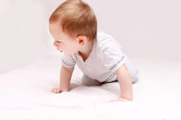 Ritratto di un bellissimo bambino di 6 mesi sorridente, strisciante sul letto — Foto Stock