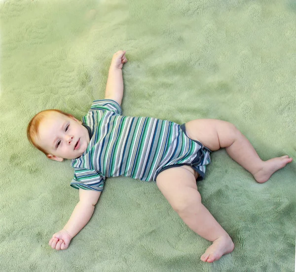 Portrait of a cute 3 months baby lying down on a green plaid — Stock Photo, Image