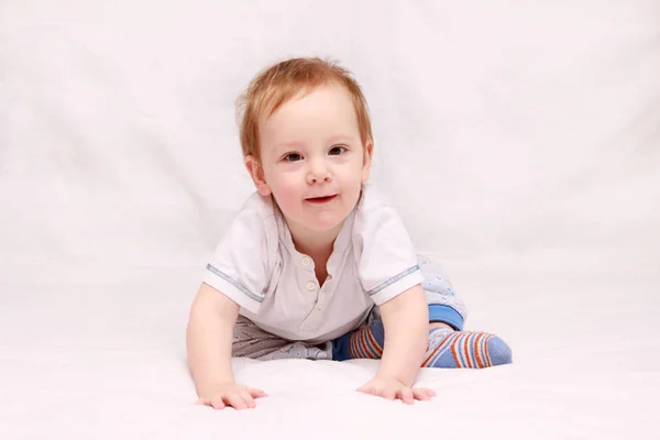 Retrato de um lindo bebê de 6 meses sorrindo, rastejando na cama — Fotografia de Stock