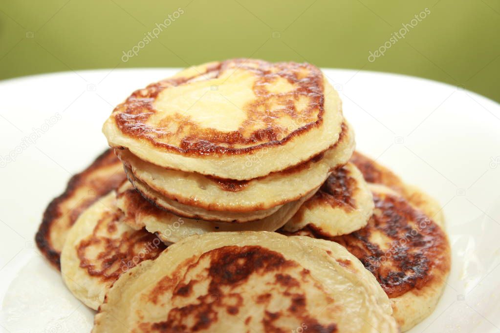 Cottage cheese pancakes or curd fritters decorated powdered sugar in plate close view. Healthy and diet breakfast